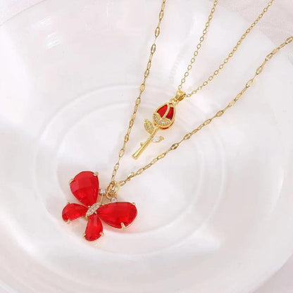 Gold-tone butterfly rose necklace with red butterfly pendant and rose stem charm