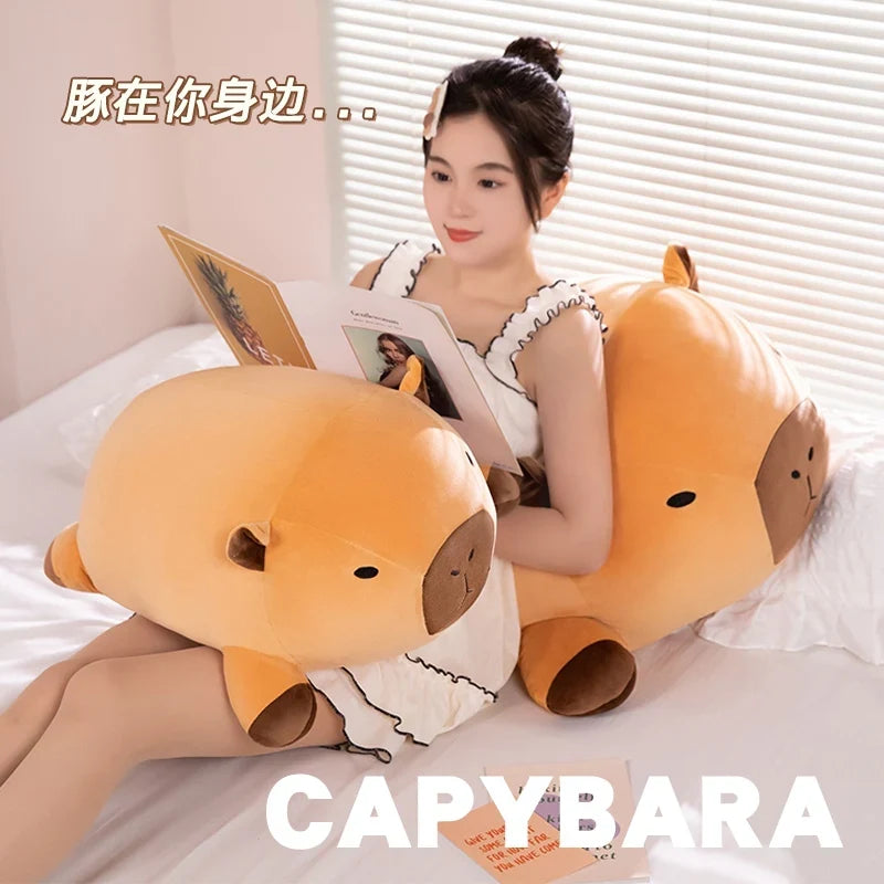 Orange capybara plush pillow with brown muzzle and rounded ears, shown in pair