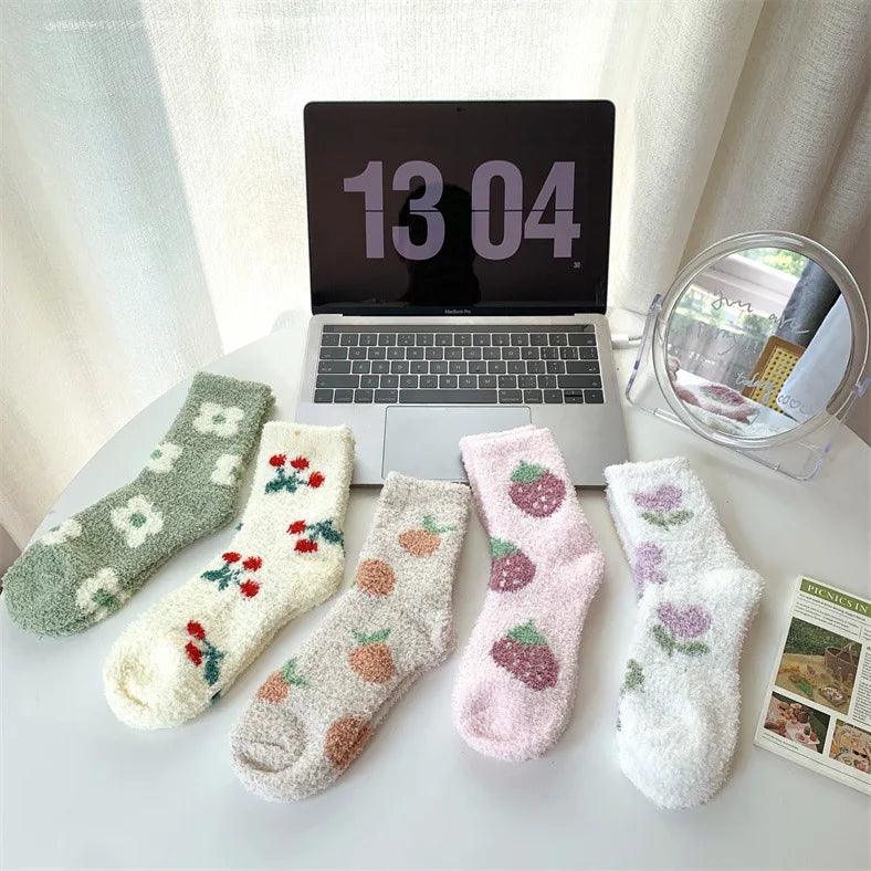 Assorted plush sleeping socks in green, cream, beige, pink, and white with fruit prints