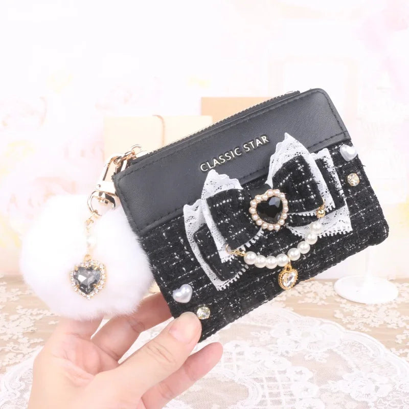 Black quilted wallet with heart charm bow, pearl trim, and gold-tone zipper