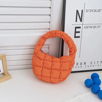 Quilted puffer circle mini bag with top handle, orange padded nylon.
