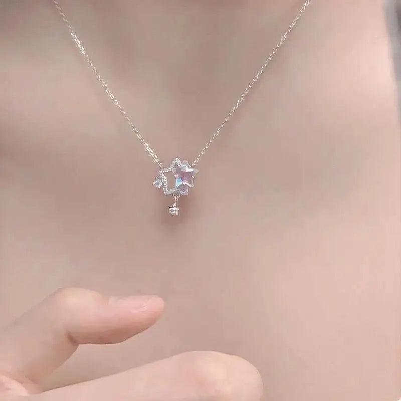 Star pendant necklace with iridescent center stone and small dangling star charm on chain