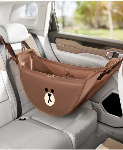 Brown car seat storage bag with bear emblem and open interior on car seat