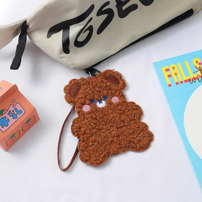 Brown plush animal photo card sleeve with strap attached on tabletop