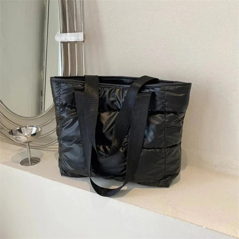 Black quilted cotton tote bag with long handles, open top, padded structured body
