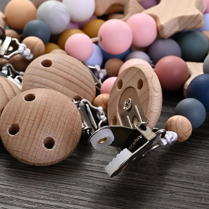 Baby pacifier clip teether chain close-up with wooden clips and silicone bead teether