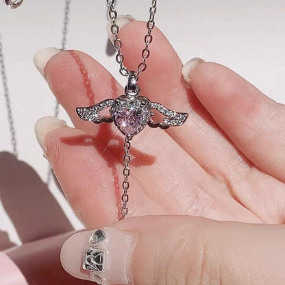 Silver-tone pink crystal angel wings heart pendant on chain, macro close-up