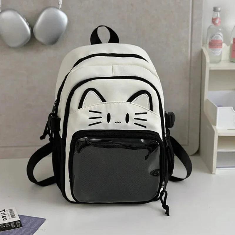 White cat school backpack with black trim; front clear pouch and adjustable shoulder straps.