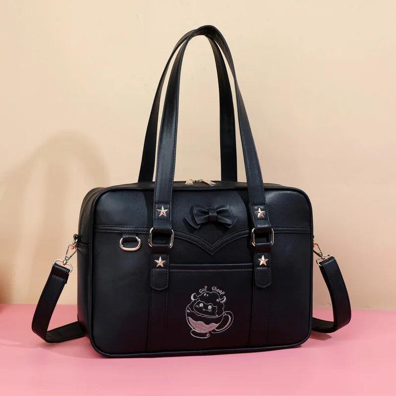 Dark blue faux-leather messenger bag with bow emblem, star accents, and crossbody strap