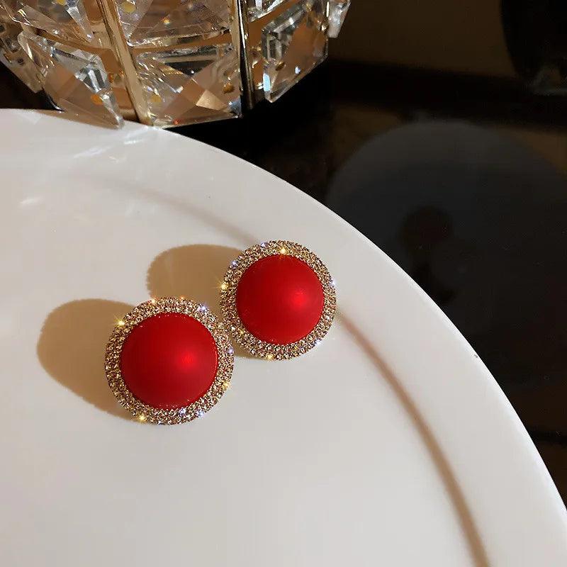 Gold-framed red round stud earrings with glittery rhinestone border