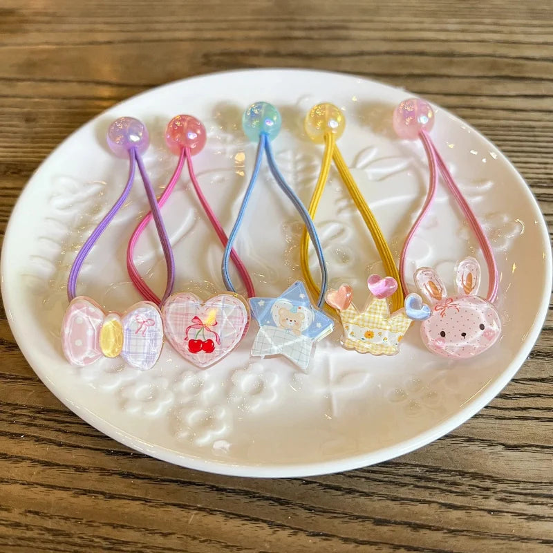 Pastel elastic hair ties with bunny and star charms, linked by looped elastic cords