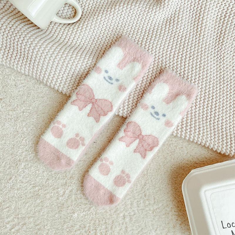 Bunny socks with white background and pink-and-blue bunny face prints, cuff to toe pattern.