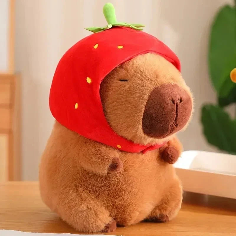 Brown plush capybara wearing a red hood with a tiny green stem on top