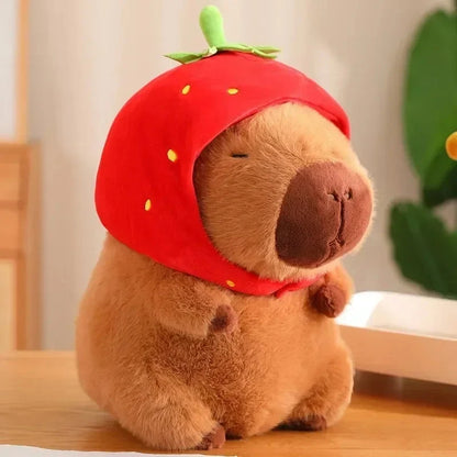 Brown plush capybara wearing a red hood with a tiny green stem on top