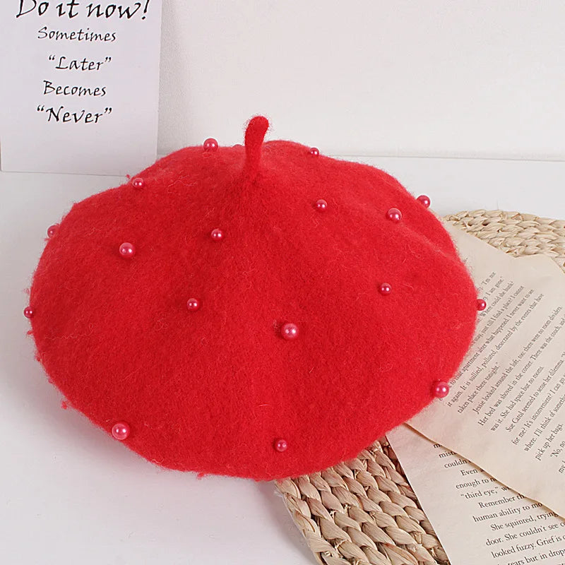 Red felt beret with faux pearl embellishments and a small center stem