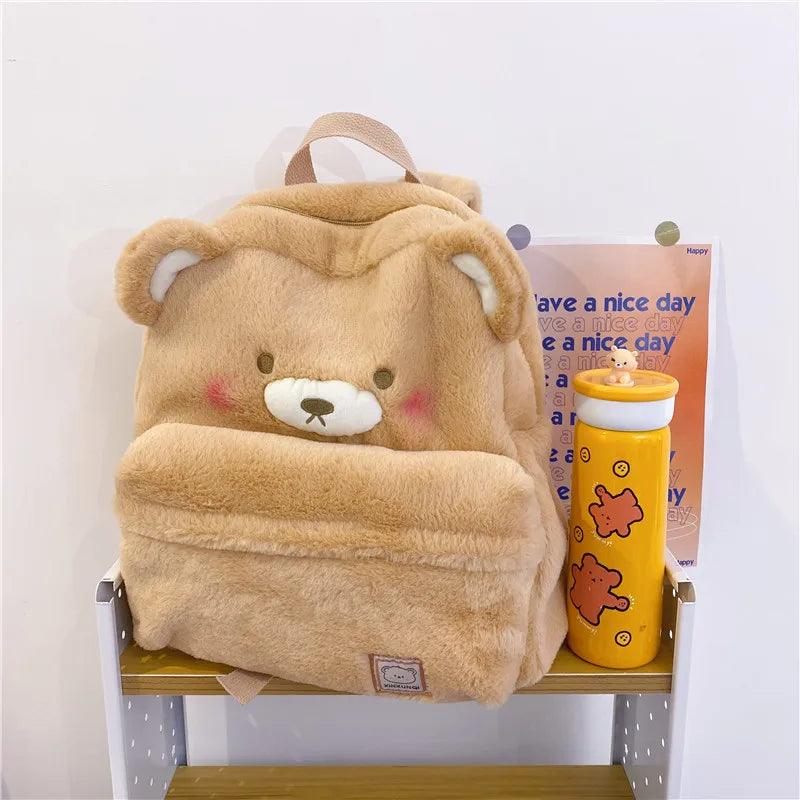 Light tan plush bear backpack with hood-like top and bear face patch on front