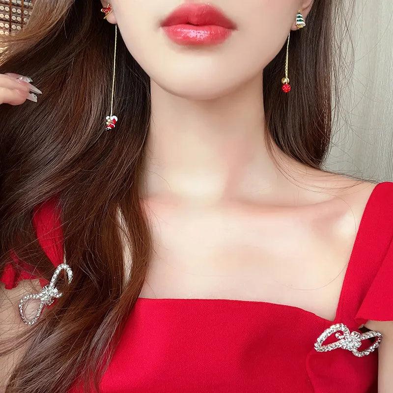 Holiday drop earrings with green tree charm and red berry dangle on gold-tone chains