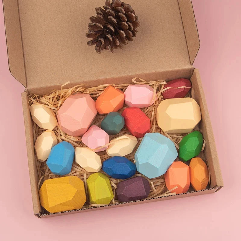Cardboard box filled with wooden sorting stacking rocks in mixed pastel and bright colors