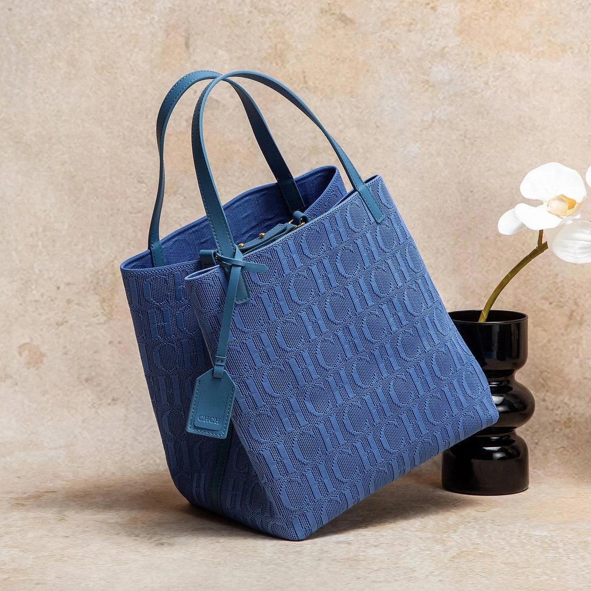 Large knitted tote bag with embossed CHCH pattern, blue shade, dual top handles.
