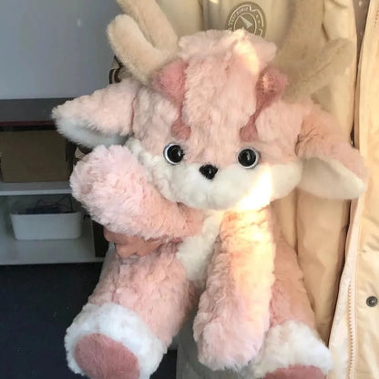 Pink plush dragon with antlers, sitting pose, white muzzle and black eyes