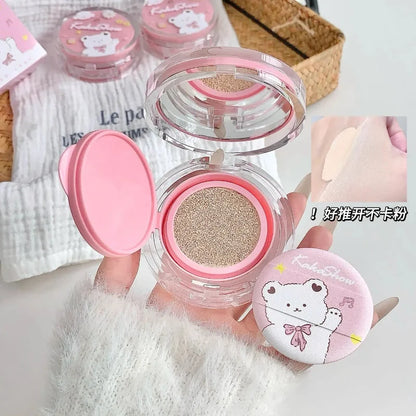 Air cushion compact open to show beige cushion powder, with pink lid and bear graphics