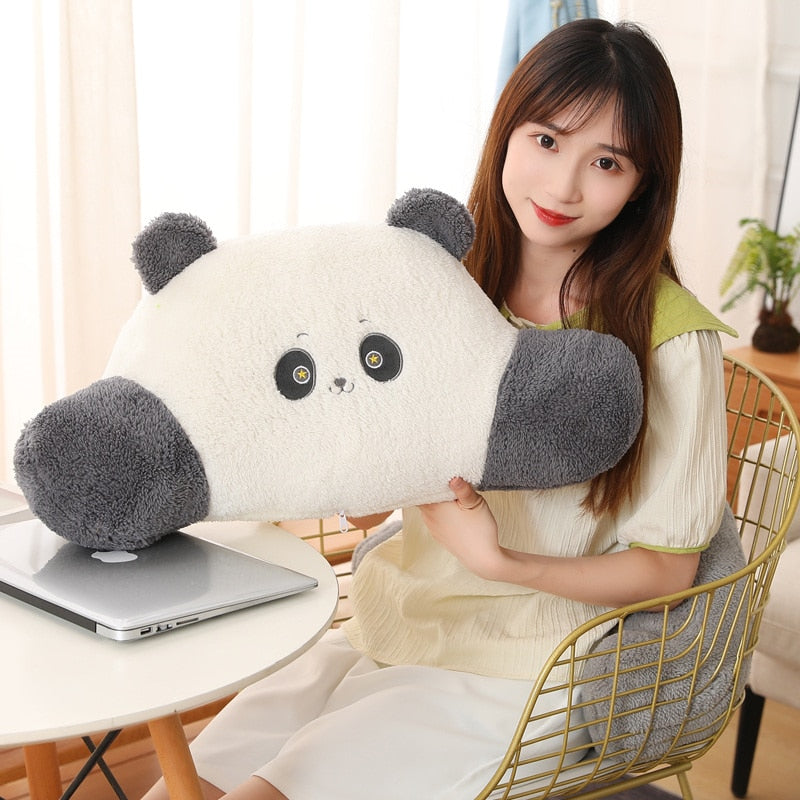 Plush panda cushion with dark gray paws and ears, held beside a laptop.