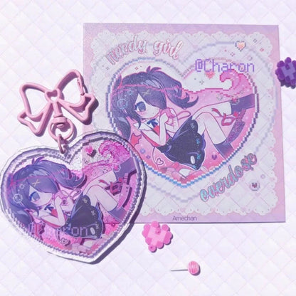 Acrylic heart keychains with pink and blue bows beside character heart charms