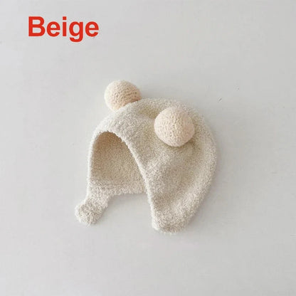 Beige kids winter ear protection hat with soft fleece earmuffs and pom-poms
