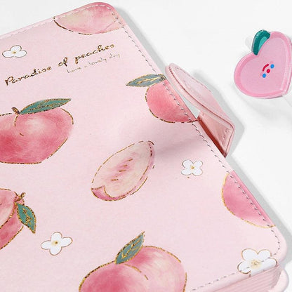 Pink notebook cover with peach illustrations, stitched edges, and decorative flap detail