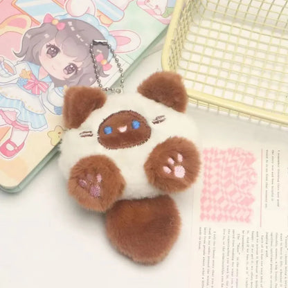 Brown cat plush keychain with white face patches, paw prints, and metal chain