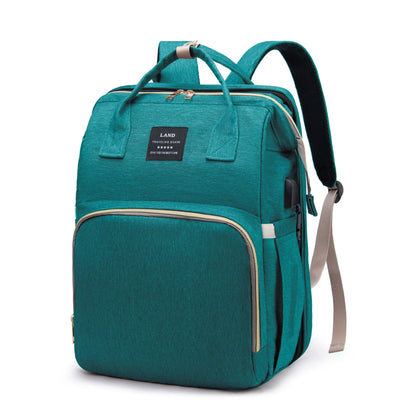 Teal diaper backpack with padded top handle, front organizer panel, and adjustable strap
