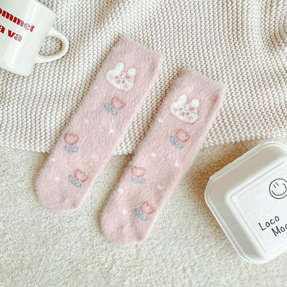 Bunny socks in pastel pink and white with paw prints and small multicolor heart accents.