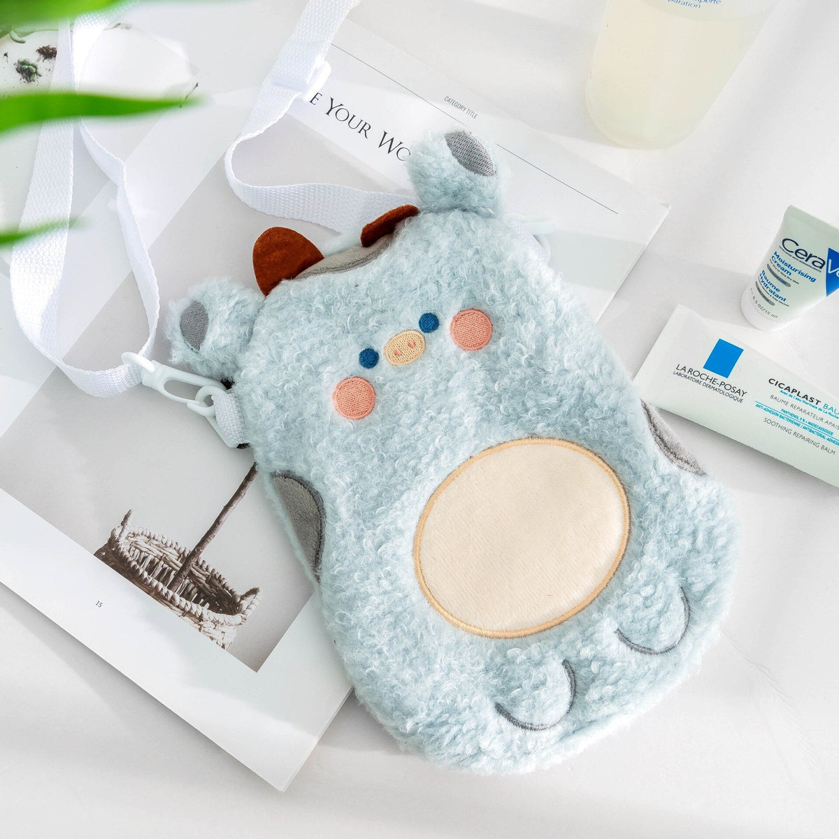 Light blue plush animal crossbody bag with stitched face and round belly patch