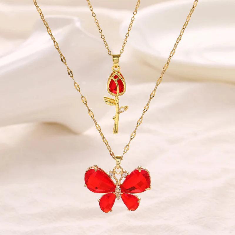 Gold-tone butterfly rose necklace with red butterfly pendant and red teardrop rose charm