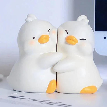 Close-up of white duck book ends facing each other with orange beaks