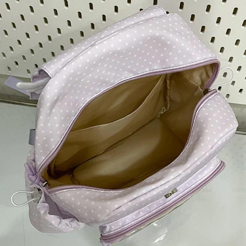 Light purple polka dot backpack open main compartment with padded lining and zipper