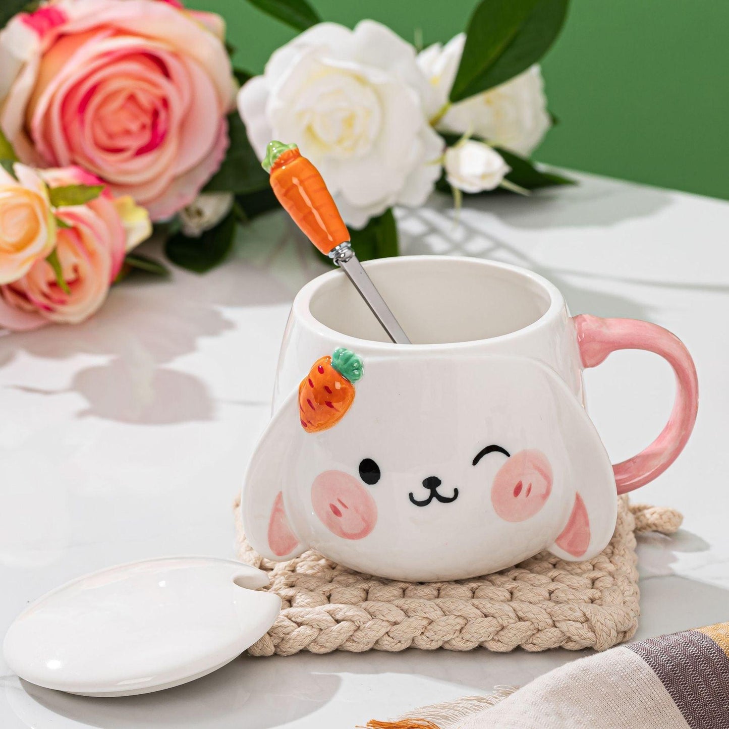 Rabbit ceramic mug with lid and carrot spoon inside, pink handle, bunny face design.