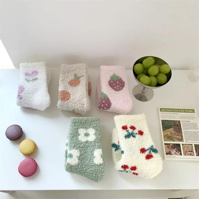 Plush sleeping socks laid flat in lavender, beige, pink, green, and cream with berry prints