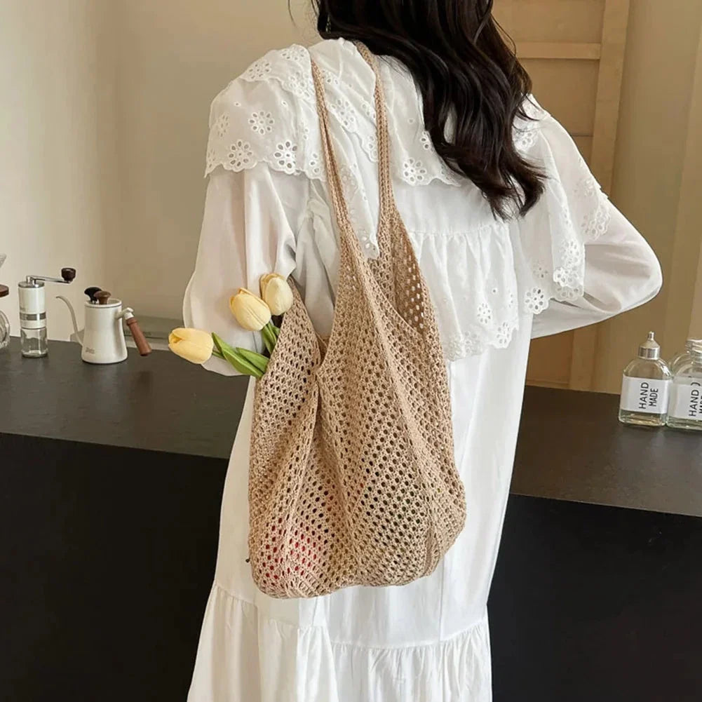 Beige knitted crochet shoulder bag with long handles, carried over shoulder