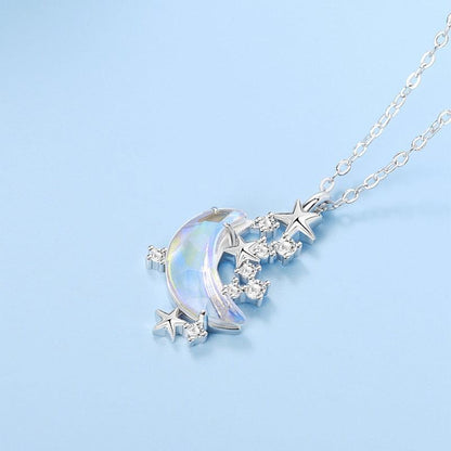 Glazed crescent moon pendant necklace with blue iridescent stone, star charms, and crystal details