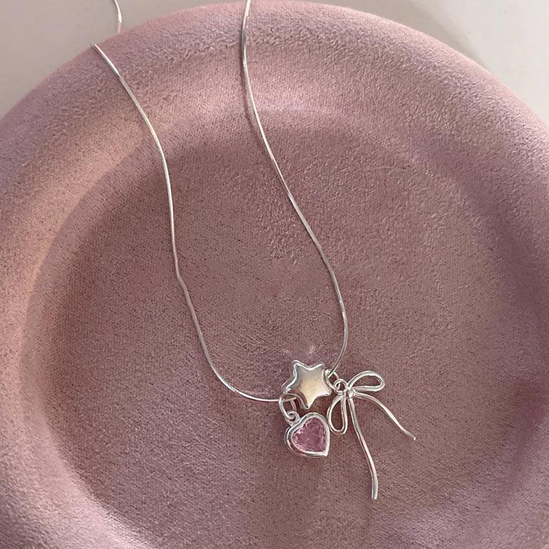 Silver star and heart charm necklace with bow accents and pink heart