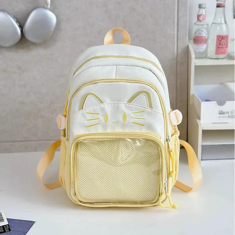 White cat-themed school backpack with yellow trim, front mesh pocket and bow straps.