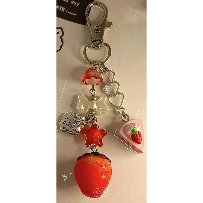 Red strawberry kawaii keychain charm with heart, flower, and strawberry slice dangle