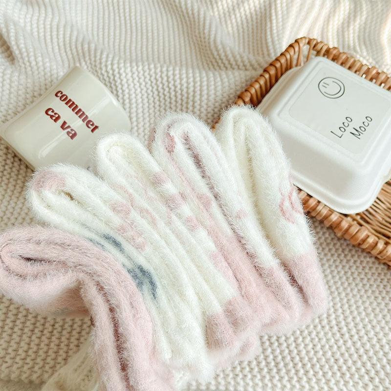 Fuzzy white socks with pastel pink and blue accents