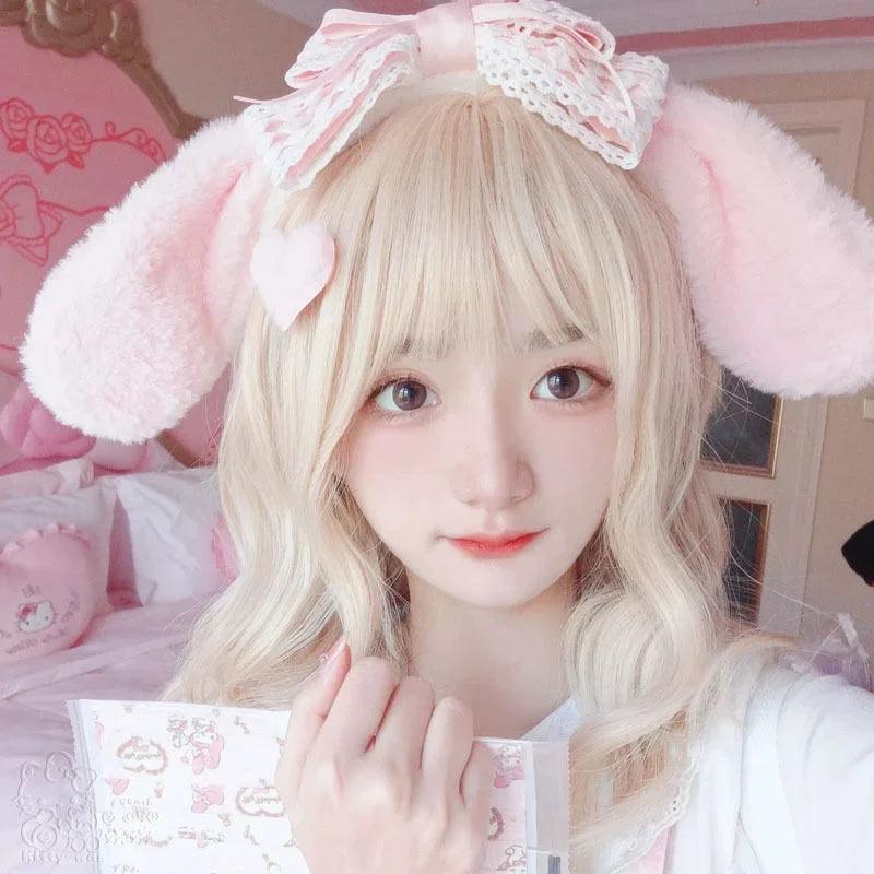 Plush bunny ear headband with pink ears and white lace bow on a pale hairband.