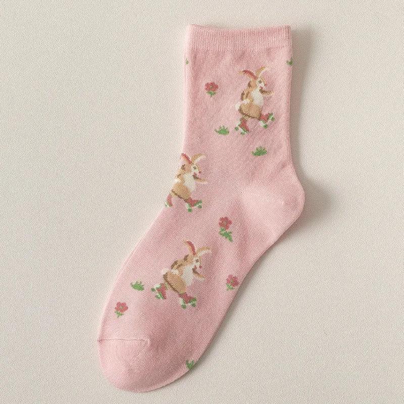 Pink socks with small bunny illustrations and tiny floral accents
