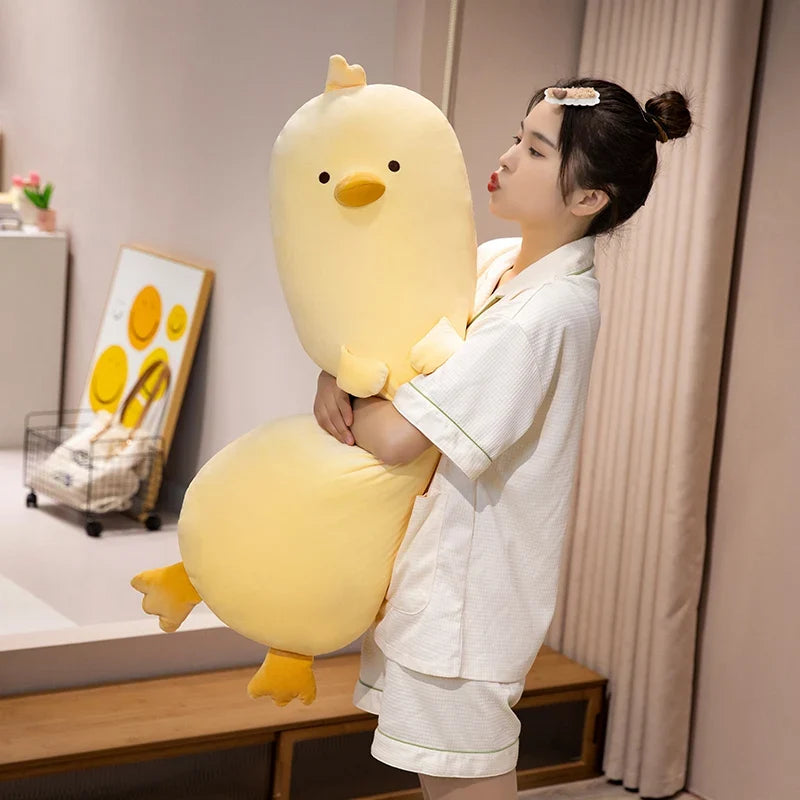Long yellow chick plush pillow with stitched beak and feet, held upright