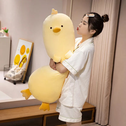 Long yellow chick plush pillow with stitched beak and feet, held upright
