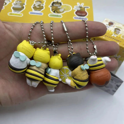 Close-up of twisted egg figure keychains with bee, honey, and cat character charms