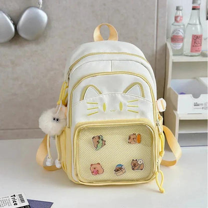 White cat school backpack with yellow trim and applique cat ears; mesh front pocket.